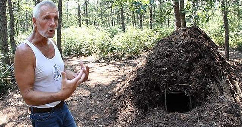 Tom Brown Jr's Tracker School: man talking in front of a bushcraft shelter