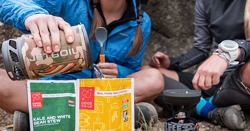 Using a jetboil to pour hot water into camping food packs