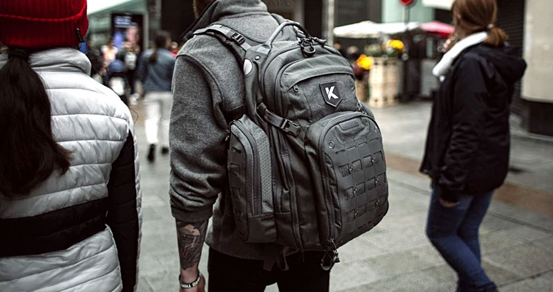 Man walking on the street with a grey maxpedition backpack