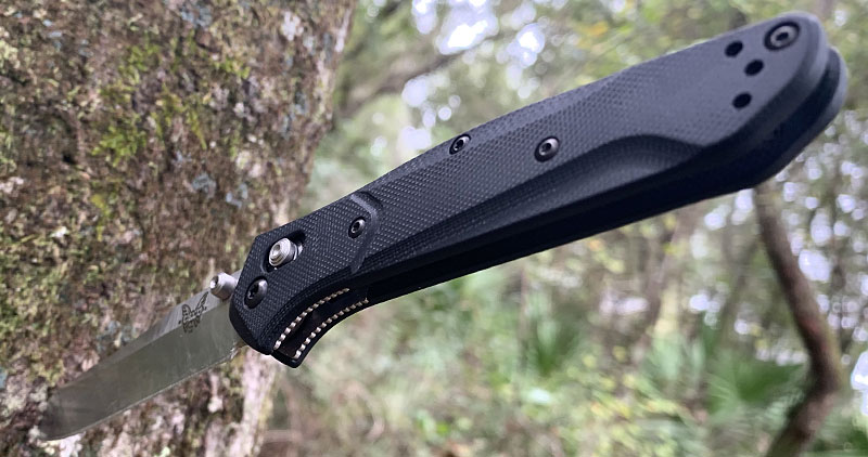 Benchmade 940-2 Osborne AXIS Lock Knife stuck point first into a tree