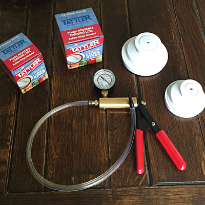 Tattler lids and brake bleeder on a table with foodsaver jar sealers