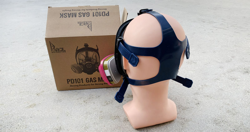 Parcil Safety PD-101 shown with 3M 60926 filters on a mannequin head on the ground, with another view of the head straps