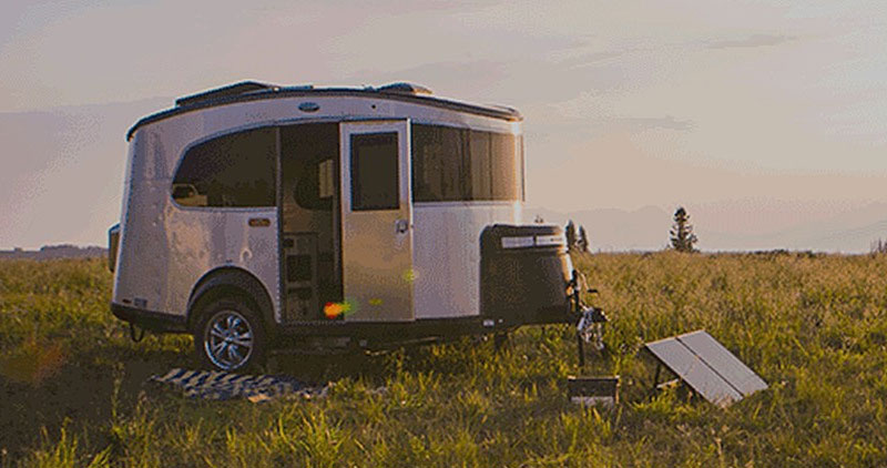 Camping trailer in a field with solar panels