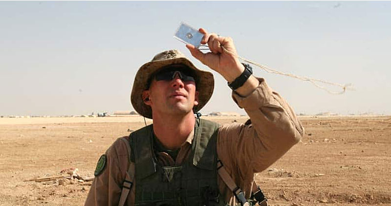 Army guy using a signal mirror