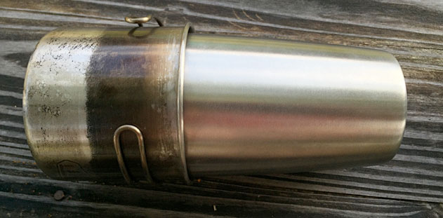 A GSI Outdoors Stainless Steel Cup 20 oz nestled over a Guyot stainless steel water canteen