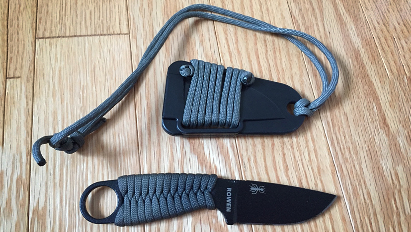 ESEE Izula knife next to its sheath with a paracord wrap on the handle and sheath
