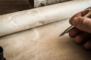 Parchment and a fountain pen in a mans hand
