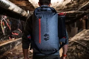 Uncharted Supply Co The SEVENTY2 Survival System on a mans back in a tunnel