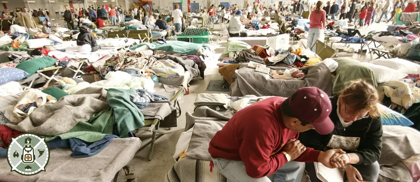 A man and woman sitting on a cot in a storm shelter