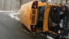 Crashed school bus on its side on a snow covered highway